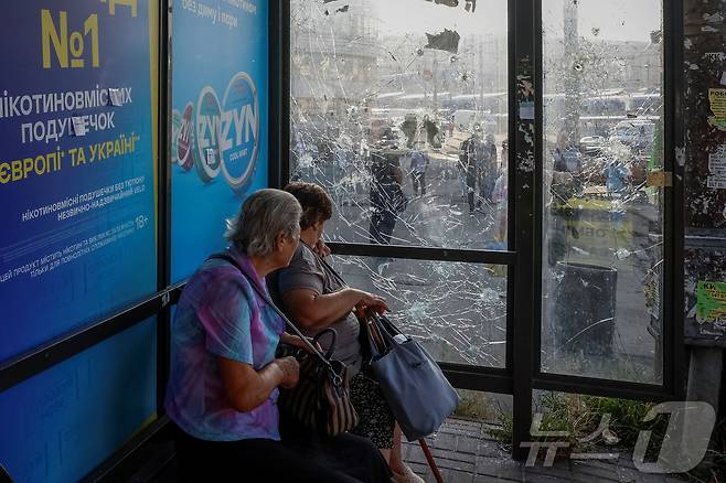 10일(현지시간) 우크라이나 키이우에서 러시아의 드론 공격으로 유리창이 깨친 버스 정류장에 여성들이 앉아 있다. 2025.07.10 ⓒ 로이터=뉴스1 ⓒ News1 최종일 선임기자
