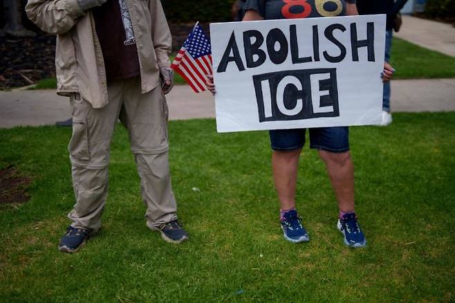 지난 11일 미국 캘리포니아주 옥스나드에서 열린 집회 참가자가 '이민세관단속국 폐지' 팻말을 들고 있다.  게티이미지 연합뉴스