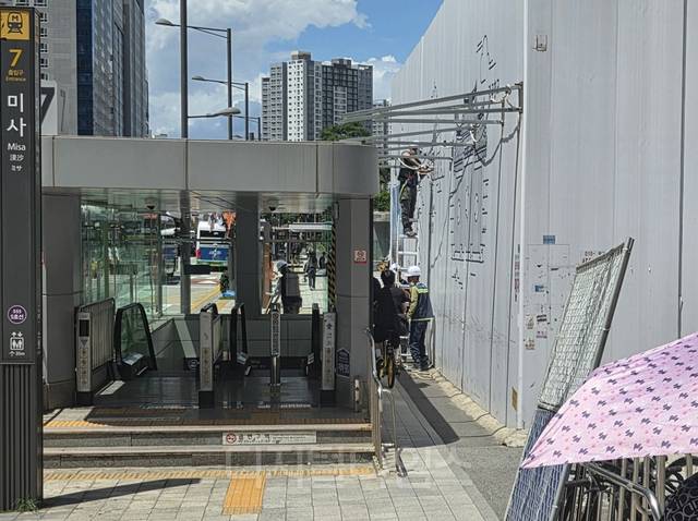 21일 하남 미사역 7번 출구 앞 오피스텔 신축현장 작업자들 사이로 시민들이 통행하고 있는 모습. 독자제공