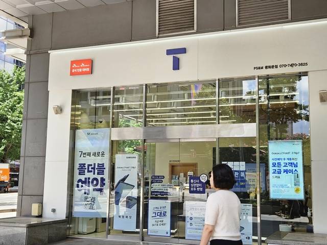 단통법 폐지 시행 전날인 21일 한 시민이 서울 광화문 SKT 매장 앞을 지나고 있다. 김나인 기자