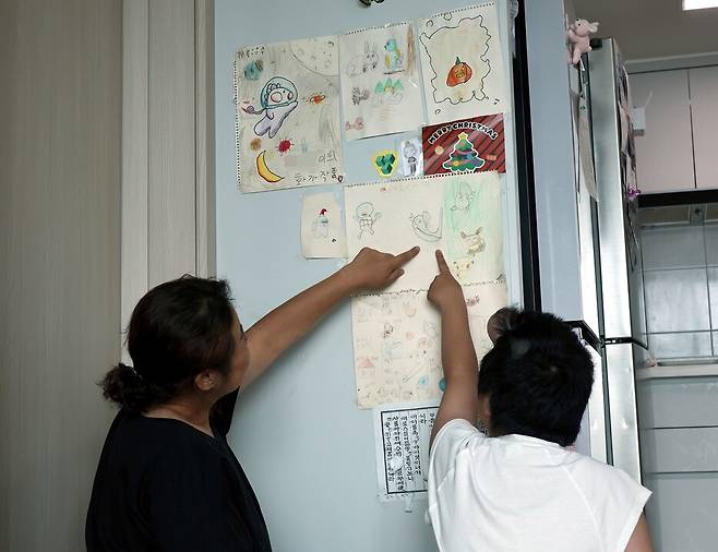 그림을 좋아하는 현아가 자신이 그린 그림들을 집 거실의 한쪽 벽면에 모아놓은 작은 전시 공간을 만들어 엄마에게 그림을 설명하고 있다. 윤운식 선임기자 yws@hani.co.kr