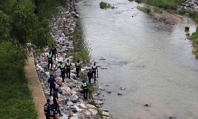 지난 18일 세종시 나성동 제천변에서 경찰이 물에 휩쓸려 실종된 40대 남성을 수색하고 있다. 연합뉴스