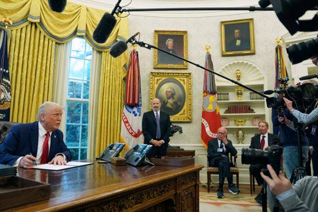 2월 3일 도널드 트럼프(맨 왼쪽) 미국 대통령이 백악관 집무실(오벌오피스)에서 행정명령에 서명하는 모습을 미 월스트리트저널의 모기업 격인 뉴스코퍼레이션의 소유주 루퍼트 머독(왼쪽 세 번째)이 의자에 앉아 지켜보고 있다. AP 연합뉴스 자료사진