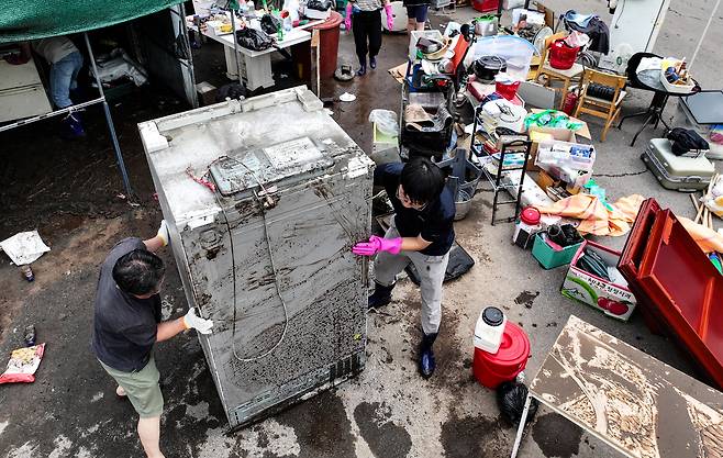 18일 전날 내린 폭우로 침수 피해를 본 대구 북구 노곡동 한 가정집에서 주민과 공무원들이 복구 작업을 하고 있다. 연합뉴스