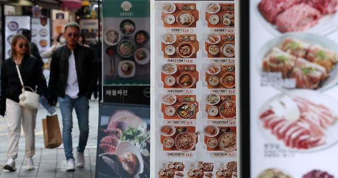 Food items and prices are featured on a restaurant menu outside a storefront in central Seoul’s Myeong-dong area in May. (Newsis)