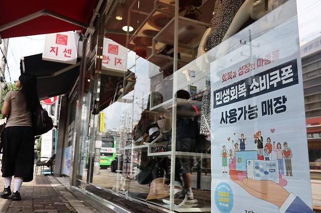 민생회복 소비쿠폰 지급을 하루 앞둔 20일 서울의 한 옷 가게에 사용 관련 안내문이 부착돼 있다. 연합뉴스