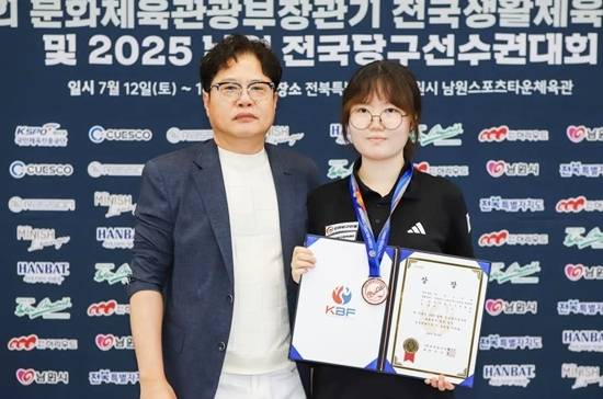 올해 초부터 당구를 배우기 시작한 조수인은 최근 끝난 남원 전국당구선수권 여고부 3쿠션에서 처음으로 공동3위에 입상했다. 시상식에서 남원당구연맹 김희원 회장(왼쪽)과 기념촬영하는 조수인. (사진=대한당구연맹)
