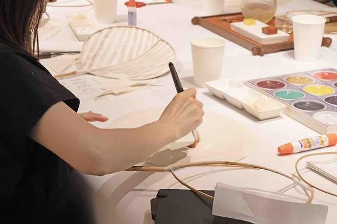 지난 18일 신세계백화점 본점 ‘더 헤리티지’ 5층에서 열린 ‘바람을 모으는 부채 만들기’ 수업. 한 참석자가 부채를 만들고 있다. <사진=신세계백화점>