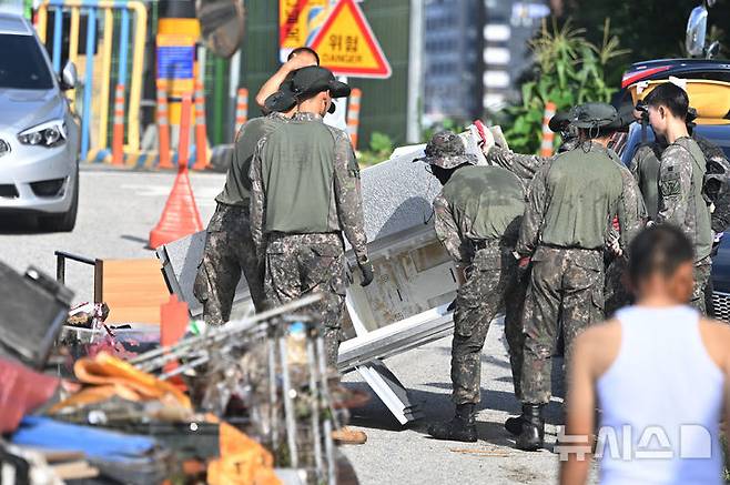[광주=뉴시스] 이영주 기자 = 20일 오전 광주 북구 신안동 서암대로 100번길 주변에서 군인들이 침수 피해 주택에서 가구들을 꺼내고 있다. 광주·전남에는 지난 사흘간 500~600㎜ 괴물 폭우가 쏟아졌다. 2025.07.20. leeyj2578@newsis.com