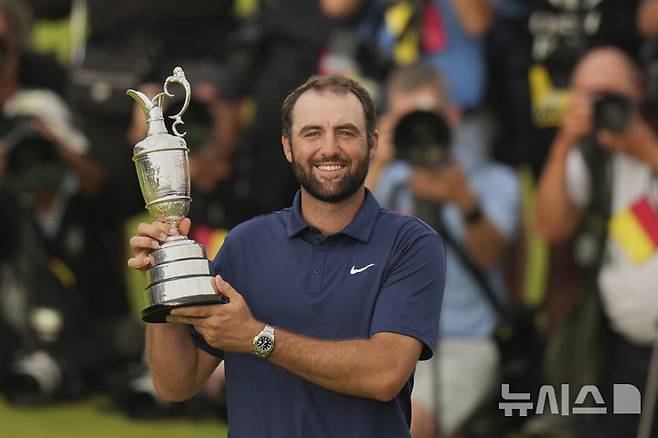 [포트러시=AP/뉴시스] 스코티 셰플러(미국)가 20일(현지 시간) 북아일랜드 포트러시의 로열 포트러시 골프클럽에서 열린 제153회 디오픈(브리티시오픈) 정상에 올라 트로피를 들고 포즈를 취하고 있다. 셰플러는 최종 합계 17언더파 267타로 우승하며 올해 메이저 대회 두 번째 정상에 올랐다. 2025.07.21.