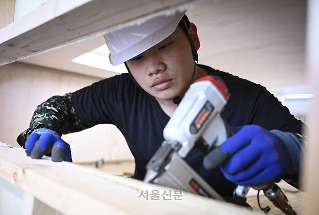 김해원씨가 지난 17일 경기 성남시 한국건설직업전문학원에서 목재를 고정하는 공구인 ‘에어 태커’를 든 채 그동안 배웠던 기술을 복습하고 있다. 이지훈 기자