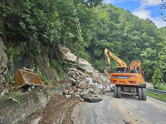 ▲ 포천시 이동면 여우고개에서 발생한 산사태로 도로를 덮친 암석을 굴착기가 치우고 있다./사진제공=포천시