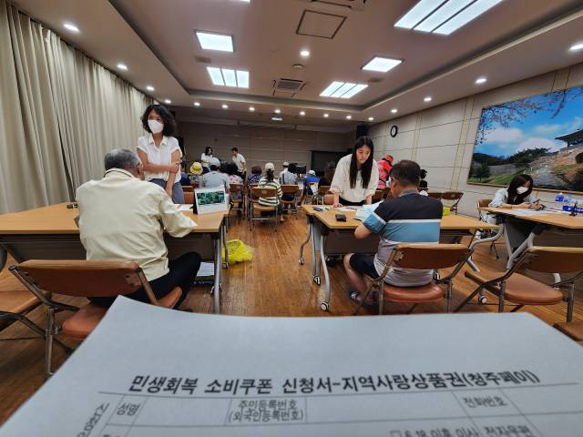 22일 청주시 청원구 우암동행정복지센터 2층 대회의실에서 주민들이 민생회복 소비쿠폰 신청서를 작성하고 있다. 사진=송휘헌 기자