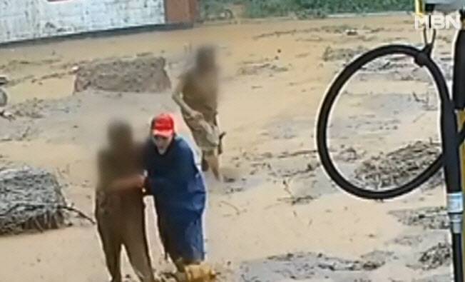 지난 19일 경남 산청에서 집중호우로 인한 산사태 당시 토사 휩쓸린 차에서 일가족 구출하고 있는 주유소 직원. (사진=MBN 캡처)