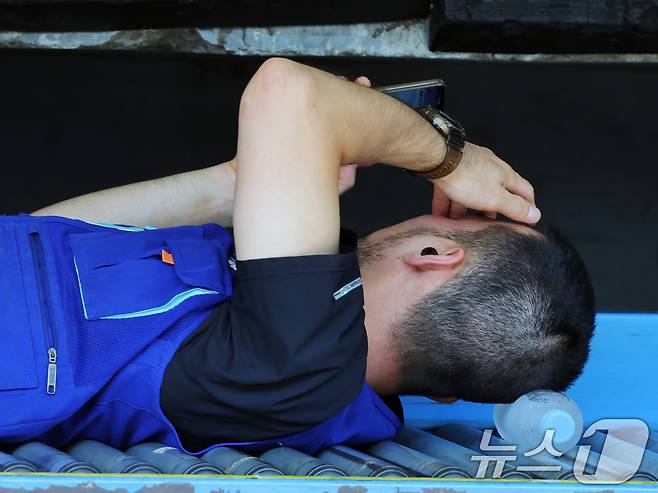 연일 폭염이 이어지고 있는 9일 서울 시내 한 택배물류센터에서 노동자가 택배 분류 작업 중 휴식을 취하고 있다. 2025.7.9/뉴스1 ⓒ News1 황기선 기자