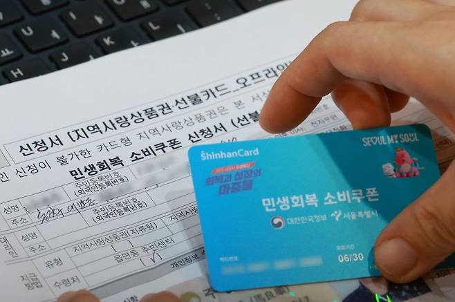 민생회복 소비쿠폰 신청이 시작된 21일 서울 동작구 대방동주민센터에서 직원이 소비쿠폰 신청을 접수하고 있다. 연합뉴스