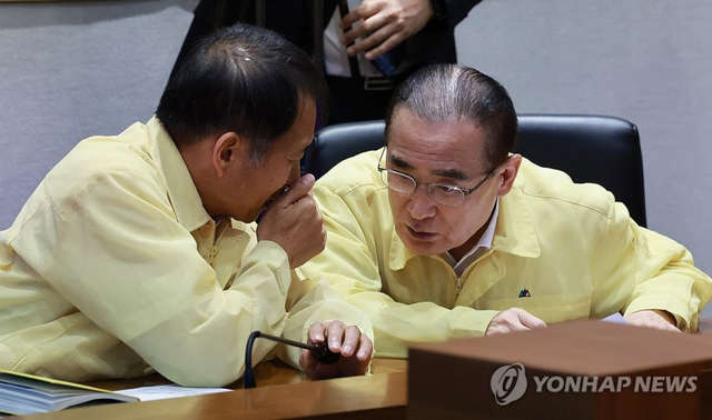 위성락 국가안보실장과 송기호 국정상황실장이 18일 정부서울청사 중앙재난안전상황실에서 열린 집중호우 대처상황 점검회의에서 대화하고 있다. 연합뉴스