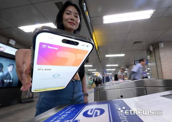 애플의 간편결제 서비스 애플페이가 22일부터 티머니 교통카드 지원을 시작했다. 22일 서울시내 한 지하철 개찰구에서 시민이 애플페이 티머니 교통카드를 태그해 지하철을 이용하고 있다. 김민수기자 mskim@etnews.com