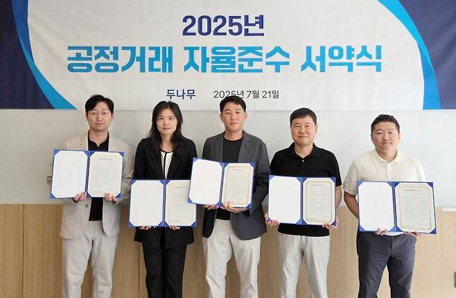 두나무 오경석 대표(CEO)가 지난 21일 서울 스퀘어큐브에서 열린 공정거래 자율준수 서약식에서 기념촬영을 하고 있다. 왼쪽부터 두나무 임종헌 CLO, 윤선주CBIO, 오 대표, 남승현 CFO, 정재용 CISO 두나무 제공