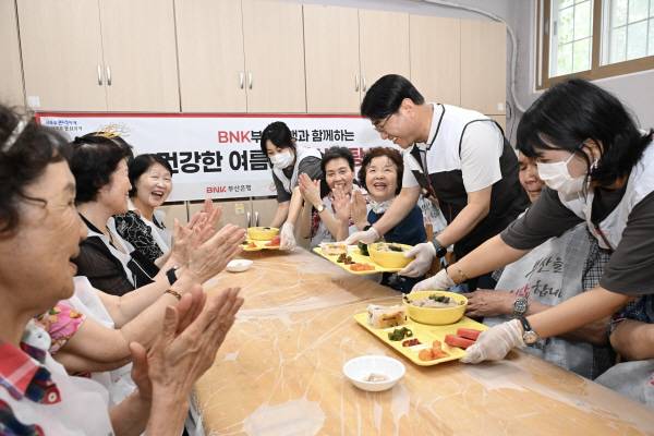 방성빈 BNK부산은행장이 초복을 하루 앞둔 19일 오전 부산의 한 복지관에서 어르신들께 삼계탕을 대접하고 있다. 연합뉴스