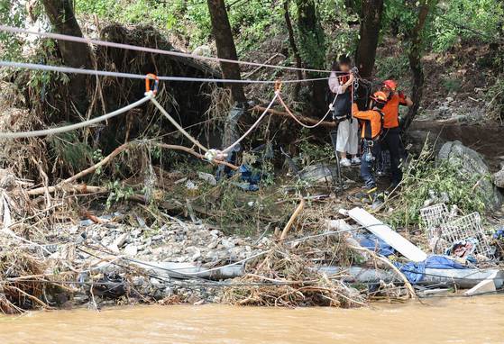 A camper is rescued by fire authorities as a landslide triggered by heavy rainfall swept the region in Mail-ri, Jojong-myeon, Gapyeong County, Gyeonggi, on July 20. [YONHAP]