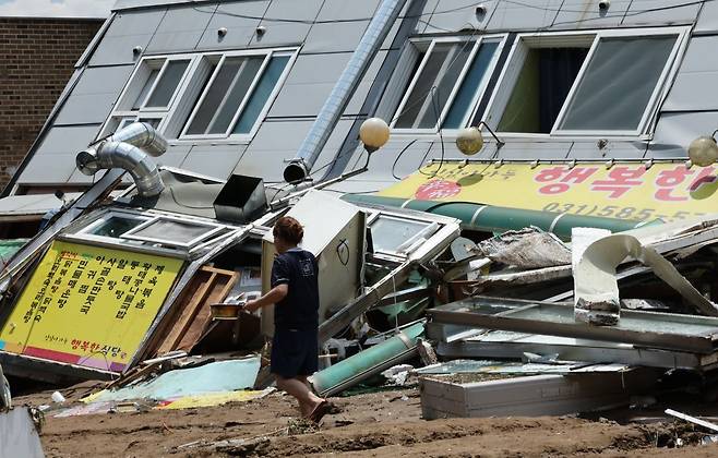 21일 경기 가평군 조종면 현리 수해 현장에서 상점 관계자가 이동하고 있다. 연합뉴스