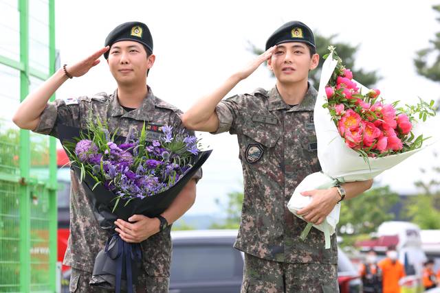 육군 현역 복무를 마치고 만기 전역한 그룹 방탄소년단(BTS) RM과 뷔가 지난 6월 10일 강원 춘천시 신북읍체육공원에서 취재진을 향해 거수경례하고 있다. 연합뉴스