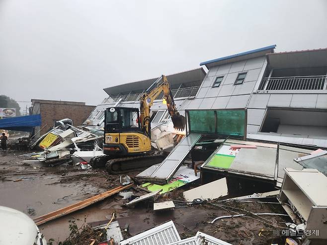 지난 20일 경기 가평군에서 집중호우로 편의점 건물이 무너져 내린 모습. 포크레인이 수해 복구 작업을 하고 있다. [독자제공]