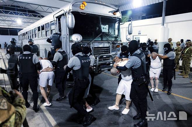 [테콜루카=AP/뉴시스] 지난달 31일(현지 시간) 엘살바도르 테콜루카 '테러범 수용소'(CECOT·세코트)에서 교도관들이 미국으로부터 추방된 이주자들을 압송하고 있다. '세코트'는 세계에서 보안 등급이 가장 높은 교도소로 미국에서 추방된 베네수엘라 이민자들도 이곳에 수감되었다. 2025.07.22.