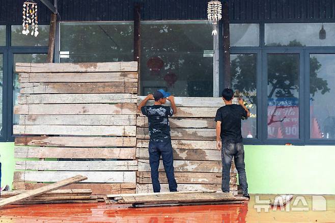 [베트남=AP/뉴시스] 21일(현지 시간) 베트남 하이퐁에서 시민들이 제6호 태풍 위파 상륙 대비를 하고 있다. 2025.07.22.