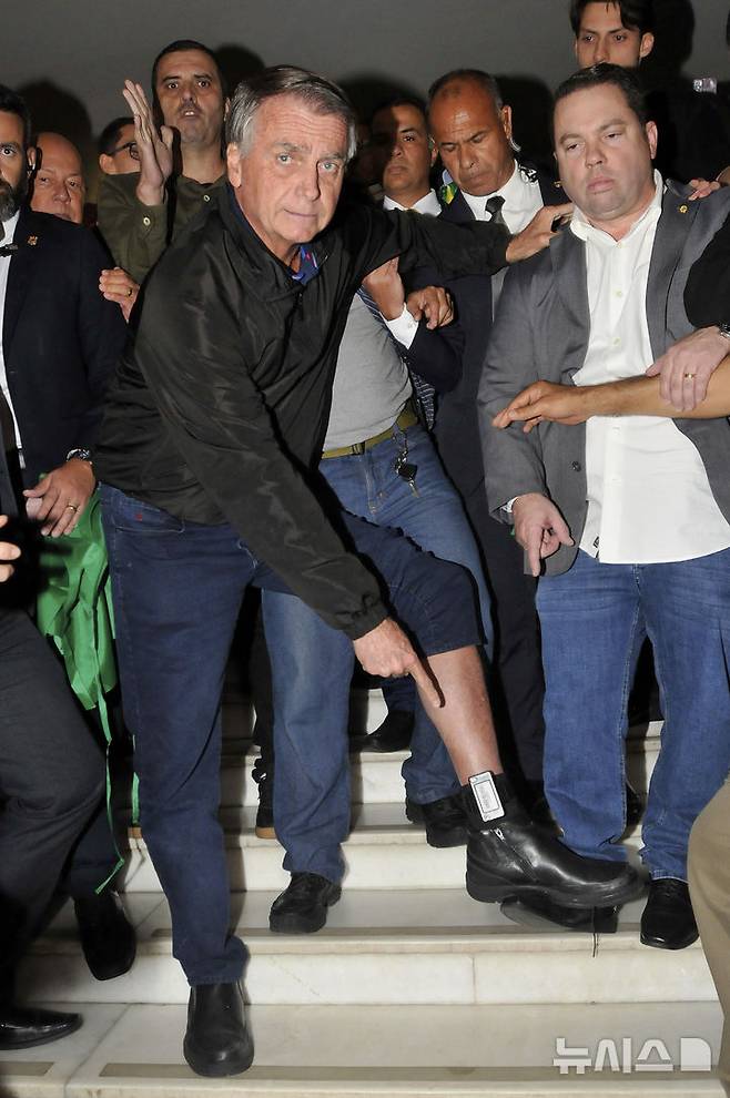 [브라질리아=AP/뉴시스] 자이르 보우소나루 전 브라질 대통령이 21일(현지 시간) 브라질리아 의회에서 발목에 착용한 전자 발찌를 보여주고 있다. 보우소나루 전 대통령은 지난 18일 브라질 연방대법원으로부터 전자 발찌 착용을 명령받았다. 2025.07.22.