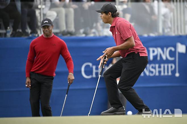 [올랜도=AP/뉴시스] 타이거 우즈의 아들 찰리(오른쪽)가 22일(현지시각) 미 플로리다주 올랜도의 리츠 칼턴 골프클럽에서 열린 PNC 챔피언십 연장 1차전에서 퍼트 실수를 범하며 아쉬워하고 있다. 우즈 부자는 최종 합계 28언더파 116타로 베른하르트 랑거(독일) 부자와 동타를 이뤄 연장 끝에 준우승을 차지했다. 2024.12.23.