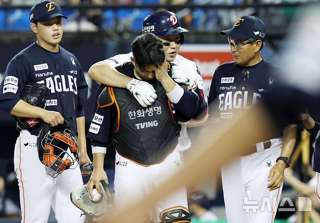 [서울=뉴시스] 홍효식 기자 = 22일 서울 송파구 잠실야구장에서 열린 2025 KBO리그 한화 이글스와 두산 베어스의 경기, 6회말 2사 한화 포수 최재훈이 두산 양의지의 헛스윙 삼진 때 마스크를 맞고 고통을 호소하고 있다. 2025.07.22. yesphoto@newsis.com