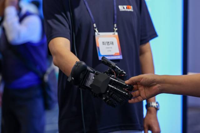 ▲ 지난 ETRI 컨퍼런스 2025에서 가상 악수 데모 콘텐츠를 시연중인 ETRI 연구진. ⓒETRI