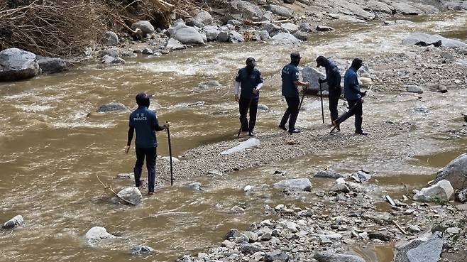 22일 오후 3시쯤 ,일가족 3명이 숨지거나 실종된 가평군 조종면 마일리 H캠핑장 입구 아래에서 경찰들이 실종자를 수색하고 있다. 찜통 더위와 뜨거운 햇살에 다소 지친 모습이다. [사진 한상봉 기자]