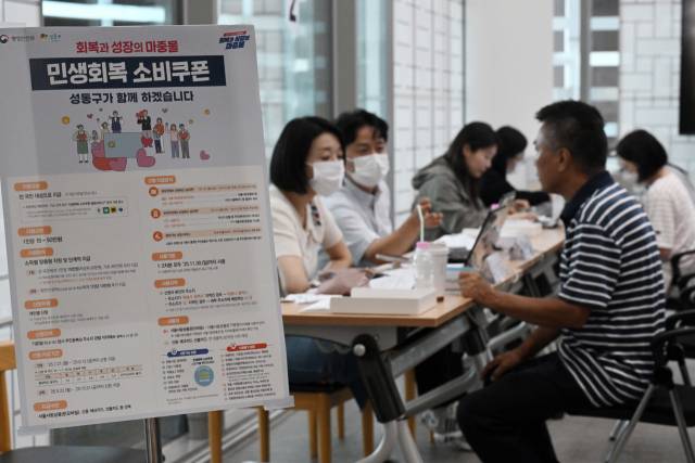 민생 경제 회복을 위한 ‘민생회복 소비쿠폰’ 신청이 시작된 21일 서울 성동구 옥수동 주민센터에 마련된 접수처에서 주민들이 소비쿠폰을 신청하고 있다. 조태형 기자 2025.07.21