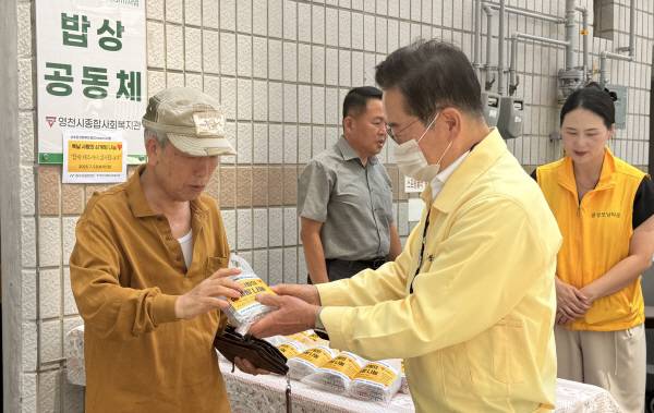 최기문 시장이 점심식사를 마치고 나오는 어르신들에게 간식으로 떡과 과일을 나눠드리고 있다. 권오석 기자