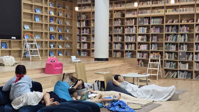 지난해 창원도서관 책담에서 ‘올빼미 밤샘 북캉스’ 행사에 참가한 시민들이 누워서 책을 즐기고 있다./경남신문DB/