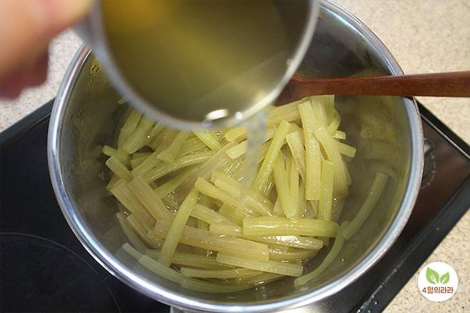 볶은 머위대에 육수를 넣는 모습