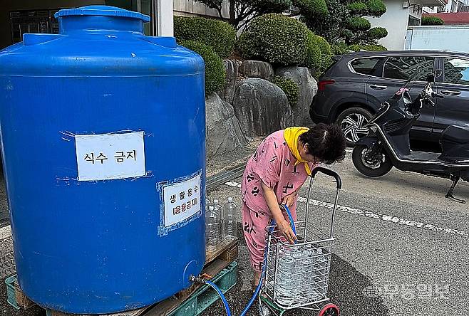 지난 22일 오후 광주 서구 유덕동 동남아파트. 한 주민이 생활용수를 받고 있다.