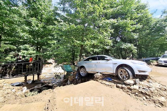 조종면 마일리 연인산로를 덮친 산사태에 휩쓸린 한 차량이 반쯤 무너져 내린 도로 끝에 위태롭게 걸려있다.(사진=정재훈기자)