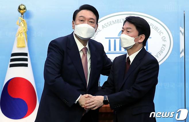 윤석열 국민의힘 대선 후보와 안철수 국민의당 대선 후보가 2022년 3월 3일 오전 서울 여의도 국회 소통관에서 단일화 기자회견을 마친 뒤 악수하고 있다. 2022.3.3/뉴스1 ⓒ News1 DB