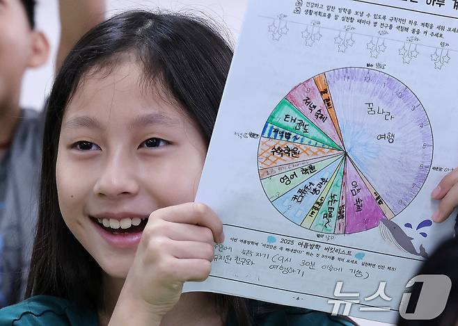 23일 서울 동작구 삼일초등학교에서 열린 여름 방학식에서 학생들이 여름방학 계획표를 들어보이며 기뻐하고 있다. 2025.7.23/뉴스1 ⓒ News1 박지혜 기자