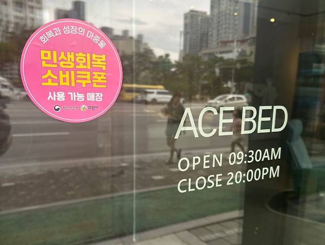 에이스침대 대리점 입구에 민생회복 소비쿠폰 사용가능매장 스티커가 붙여 있다. 에이스침대 제공