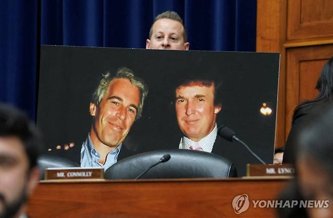 지난해 1월 10일 미국 워싱턴DC 국회의사당에서 민주당의 자레드 모스코워츠 하원의원이 과거 도널드 트럼프 미국 대통령(오른쪽)과 제프리 엡스타인이 함께 찍은 사진을 들고 있다.로이터연합뉴스