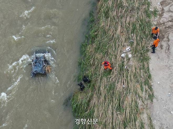 22일 경기 가평군 조종면 대보리에서 관계자들이 침수 차량에 대해 수색 작업을 벌이고 있다. 가평 | 성동훈 기자