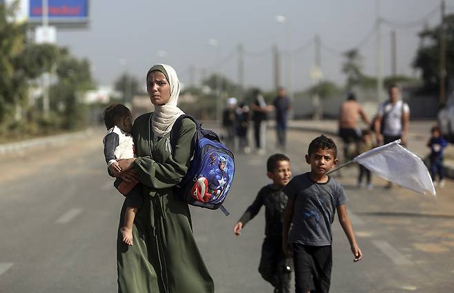 2023년 11월, 한 팔레스타인 여성이 백기를 든 아이들을 데리고 가자지구 남쪽으로 피란을 가고 있다. AP연합뉴스