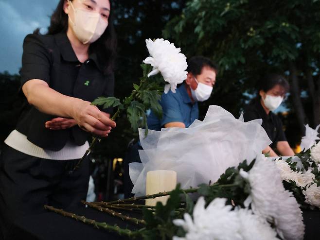 오송 지하차도 참사 유족들이 참사 2주기인 지난 15일 오후 충북도청 앞에서 열린 추모제에 참석해 위패 앞에 헌화하고 있다. 연합뉴스