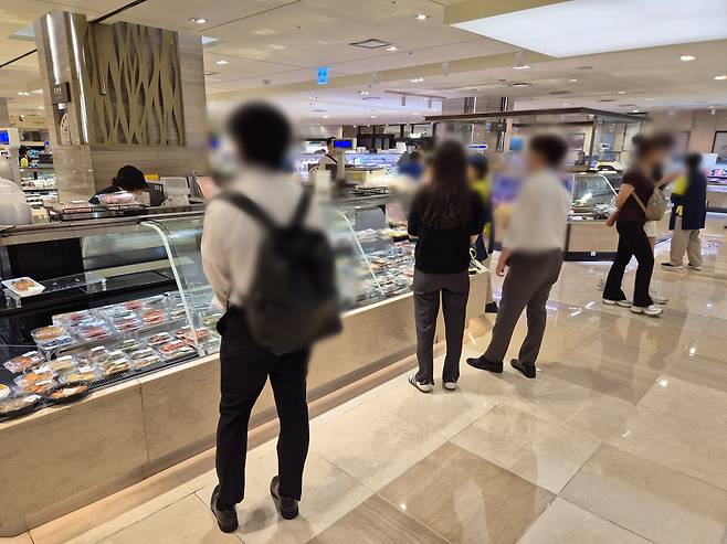 A side dish corner at a department store in central Seoul's Jung District on July 21 after 6 p.m. lures office workers looking to buy items on sale. [LIM SUN-YOUNG]