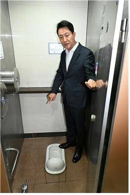 오세훈 시장이 잠실역 화장실에 설치된 화변기를 보고 있다. [서울시 제공]